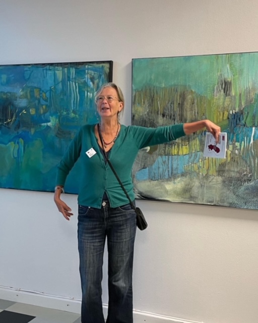 Bildtext: Siri K- Karlsson framför sina målningar. Foto Maja-Lena Molin, chef Södertälje konsthall.